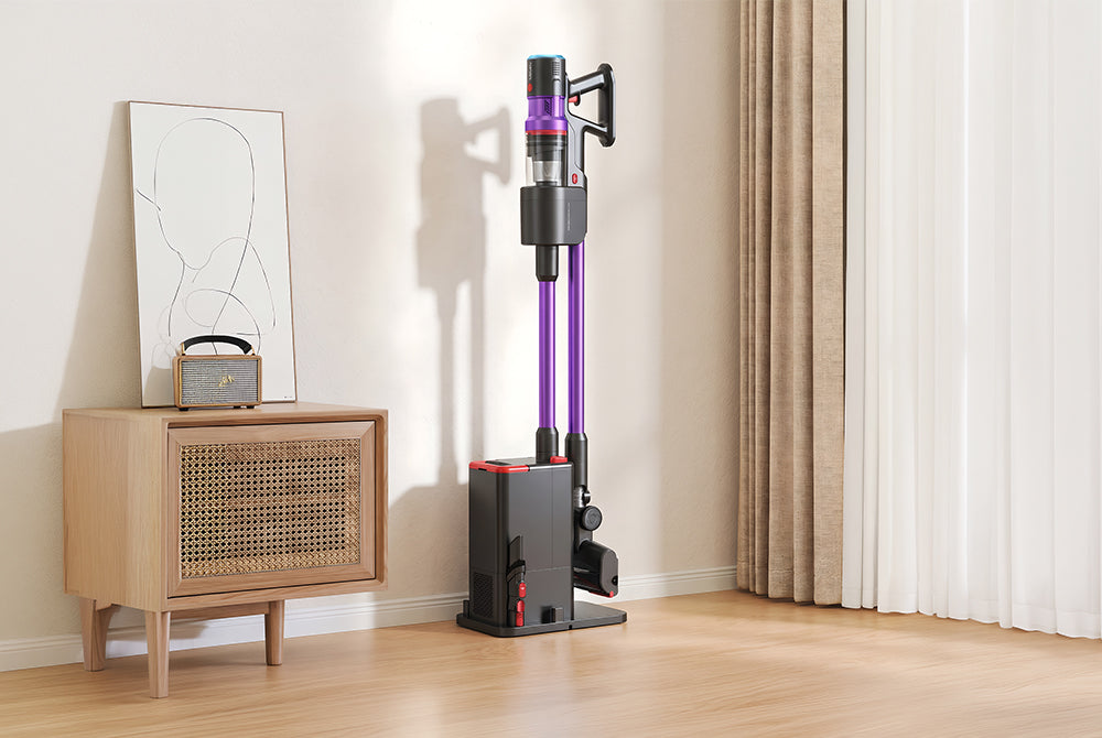 Dyson vacuum cleaner on a wooden floor with a light-colored wall and curtain in the background