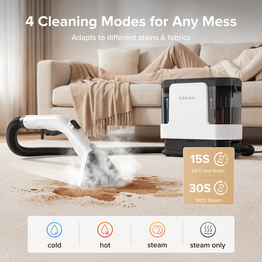 A portable steam cleaner shown in a living room setting, cleaning a brown stain on a beige carpet in front of a sofa. The product is white and black with a flexible hose.