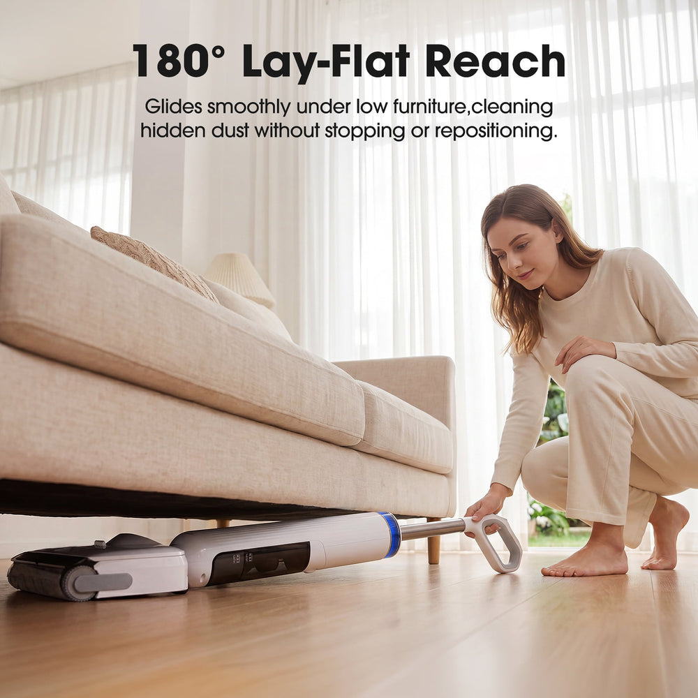 Woman using a vacuum cleaner with '180¡ã Lay-Flat Reach' feature under a couch.